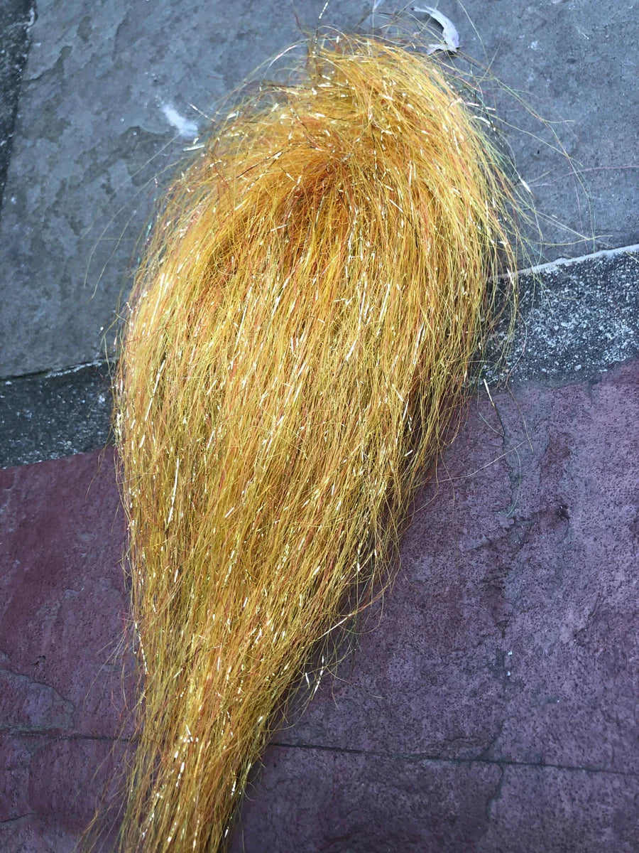 Close-up of vibrant golden-yellow synthetic fishing lure material with sparkling fibers, designed for creating Squimpish Sparkle Blend fishing tackle to attract fish.