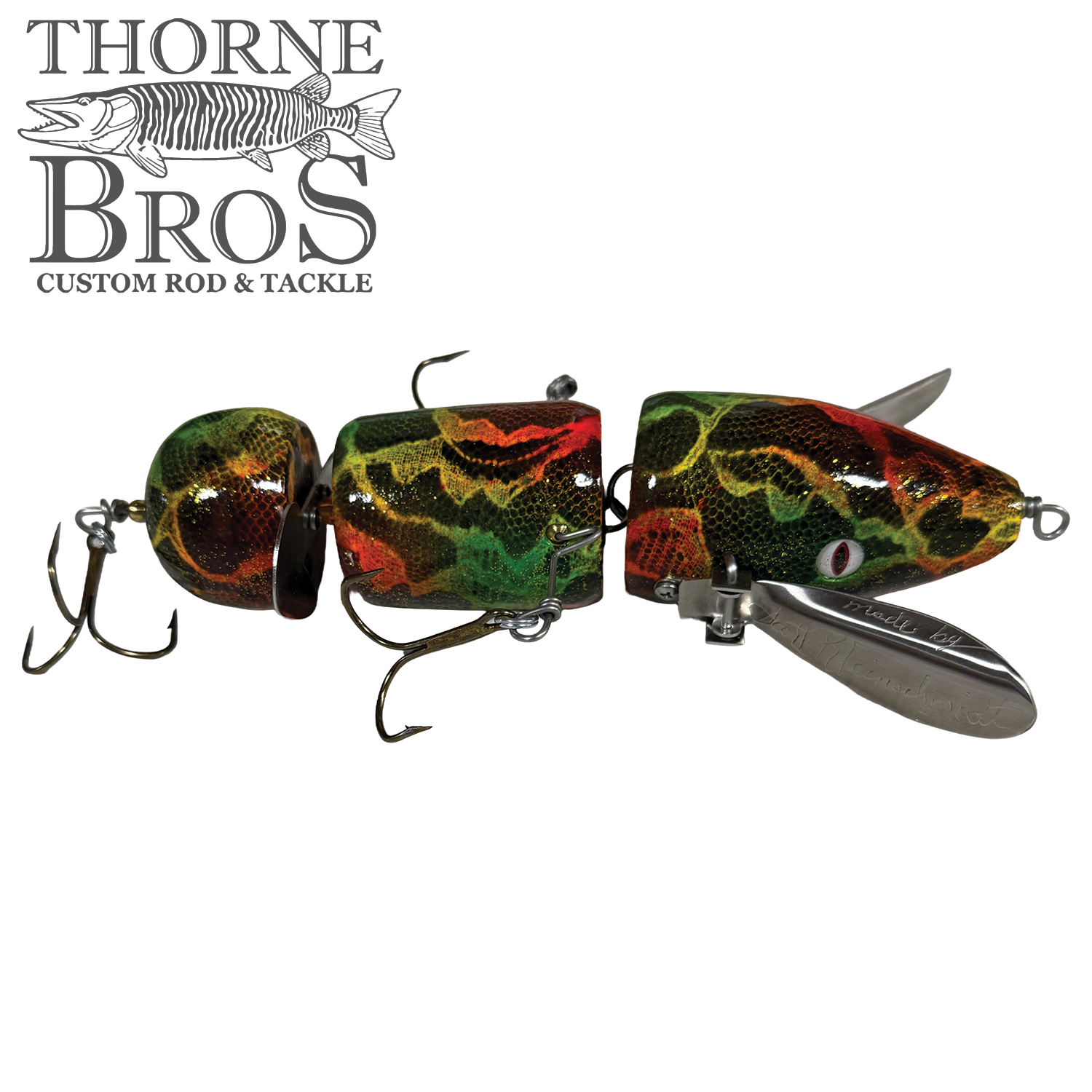 Musky Safari Franken Spitz fishing lure with segmented body in green, red, and yellow camouflage pattern, equipped with multiple treble hooks and metal diving lips for musky fishing.