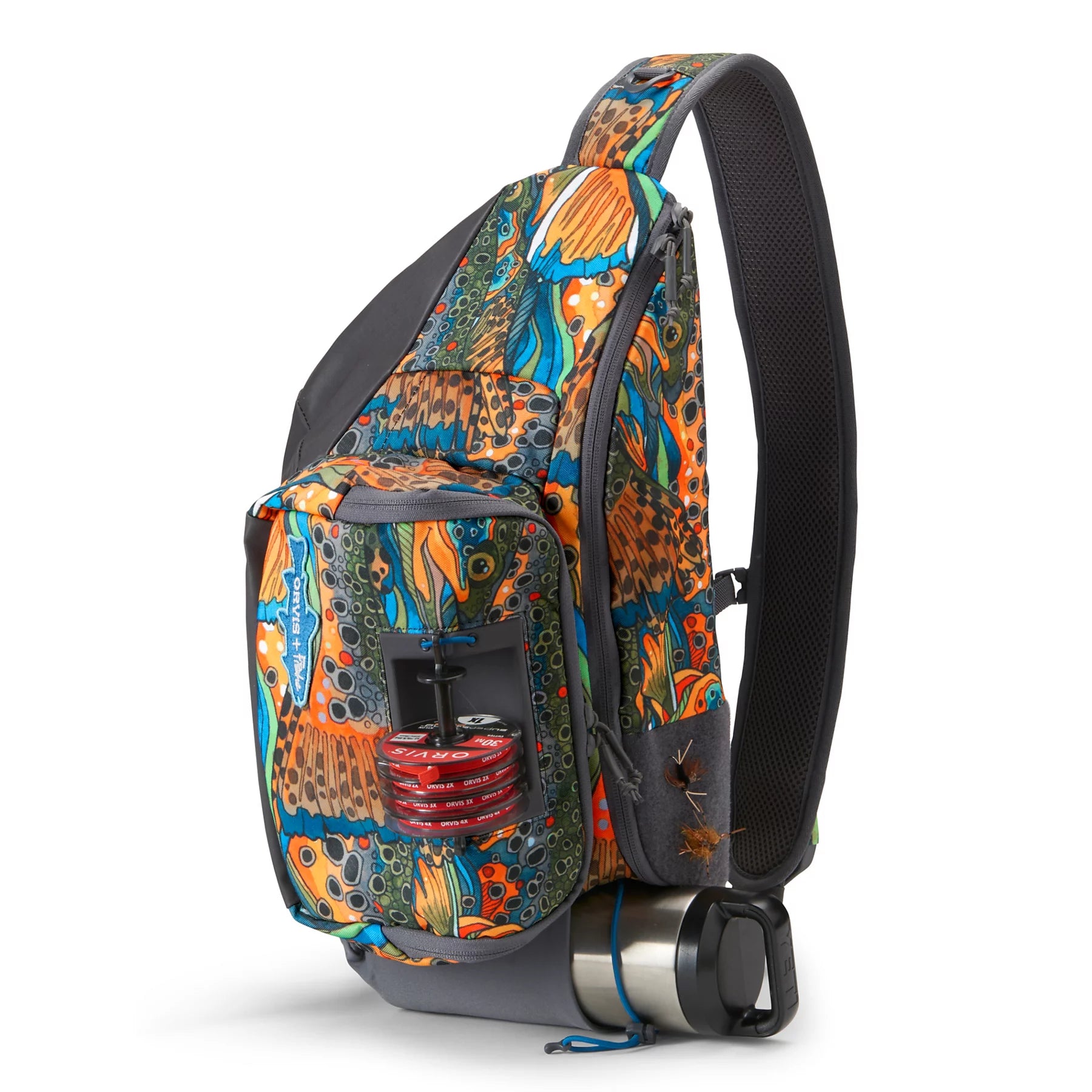 Orvis Sling Pack featuring a colorful fish scale pattern, single padded shoulder strap, multiple zippered compartments, and external attachments for fishing tackle and gear.
