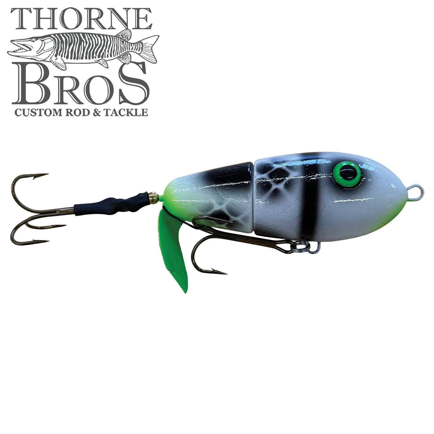 Lake-X Fat Bastard fishing lure with segmented body in blue, white, and black colors, featuring green eye detail and two treble hooks for musky fishing tackle.