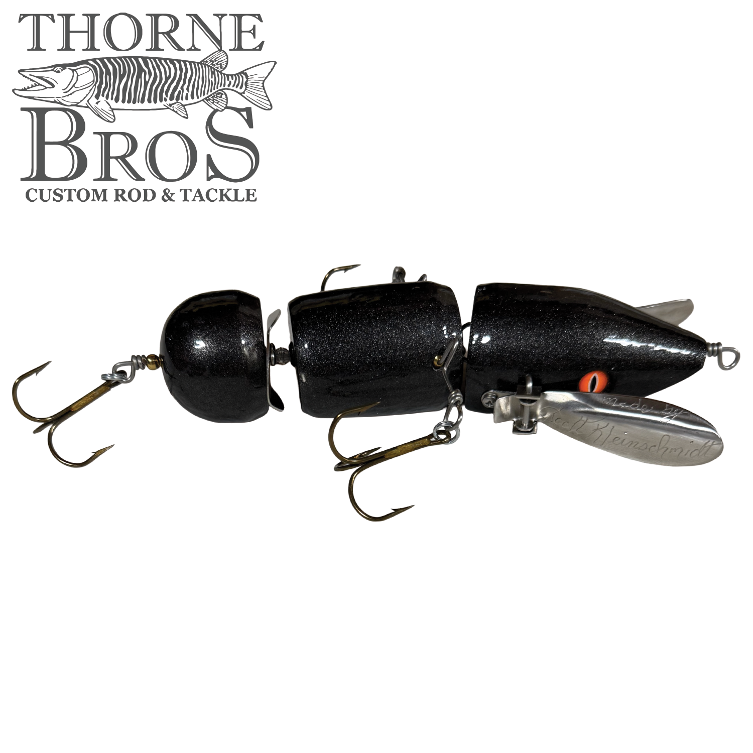 Musky Safari Franken Spitz fishing lure in black with segmented body, orange eyes, and multiple treble hooks designed for musky fishing from Thorne Bros.