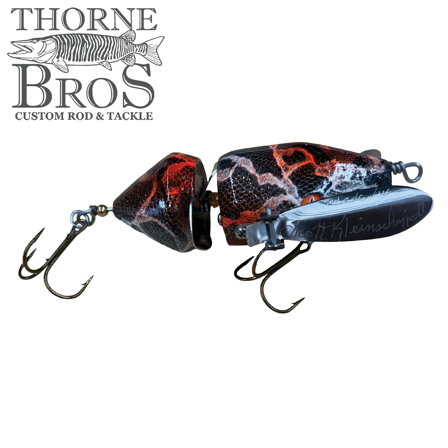 Musky Safari Mini Baby Spitzer fishing lure with segmented red and black body, featuring two treble hooks and a metal lip for bait movement in water.