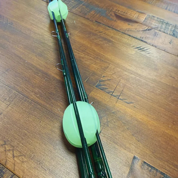Trxstle Flex-Lock Silicone Rod Keeper securing multiple fishing rods with bright green silicone loops on a wooden surface for organized fishing tackle storage
