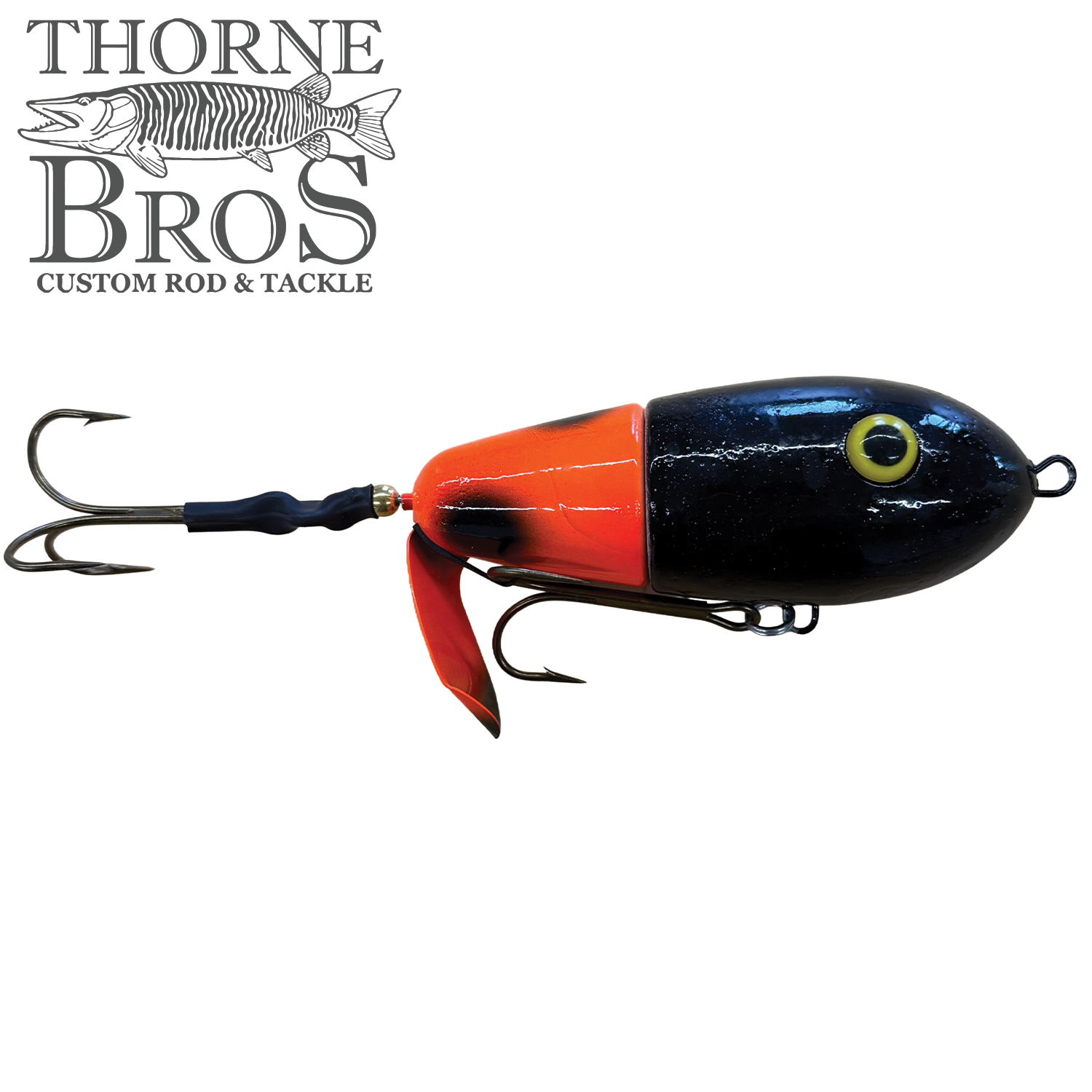 Lake-X Fat Bastard fishing lure in black and bright orange with detailed eyes and multiple treble hooks, designed for musky fishing by Thorne Bros.