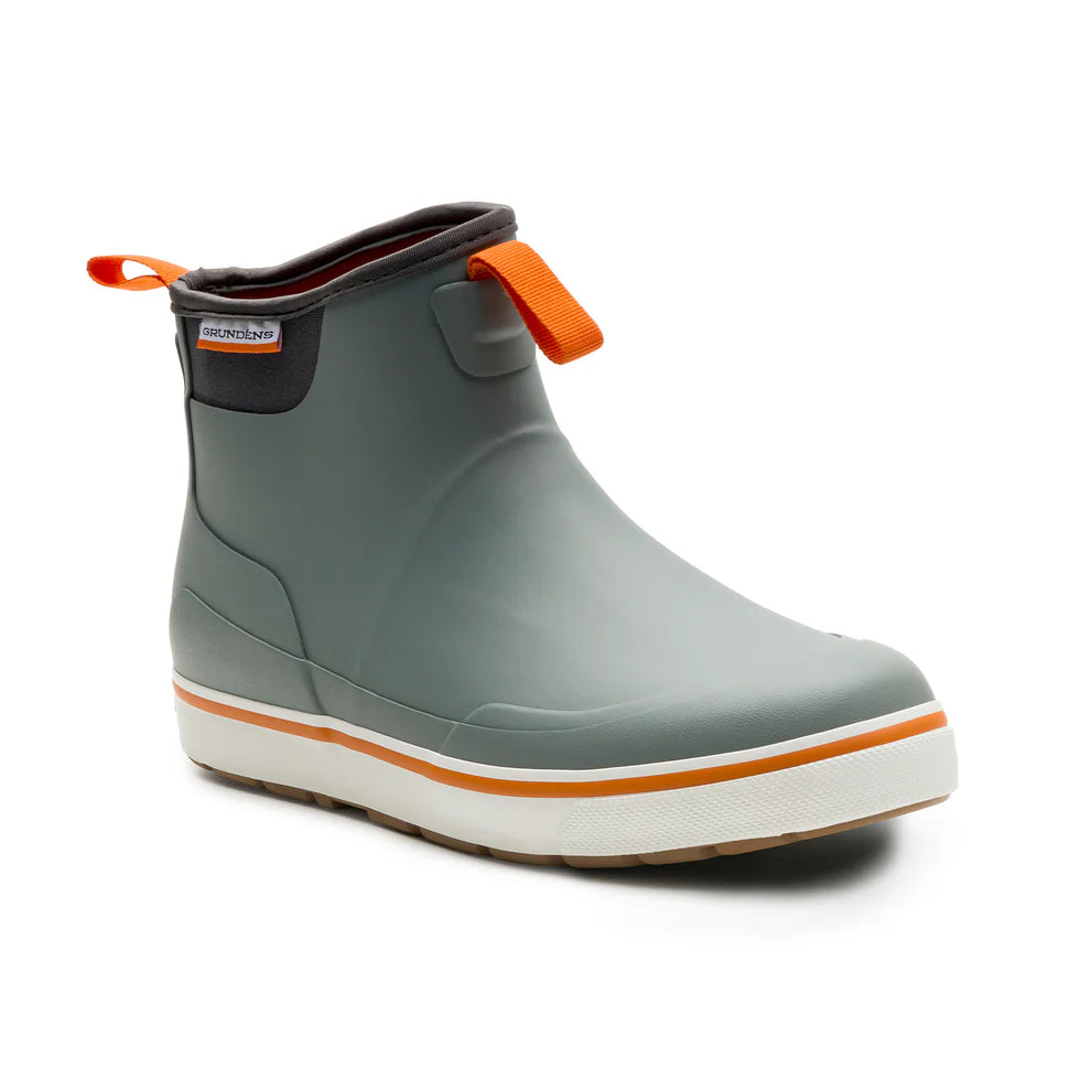 Grundens Deck-Boss Boot in gray with orange pull tabs, featuring a waterproof rubber construction and a slip-resistant white and orange sole designed for durability in fishing environments.