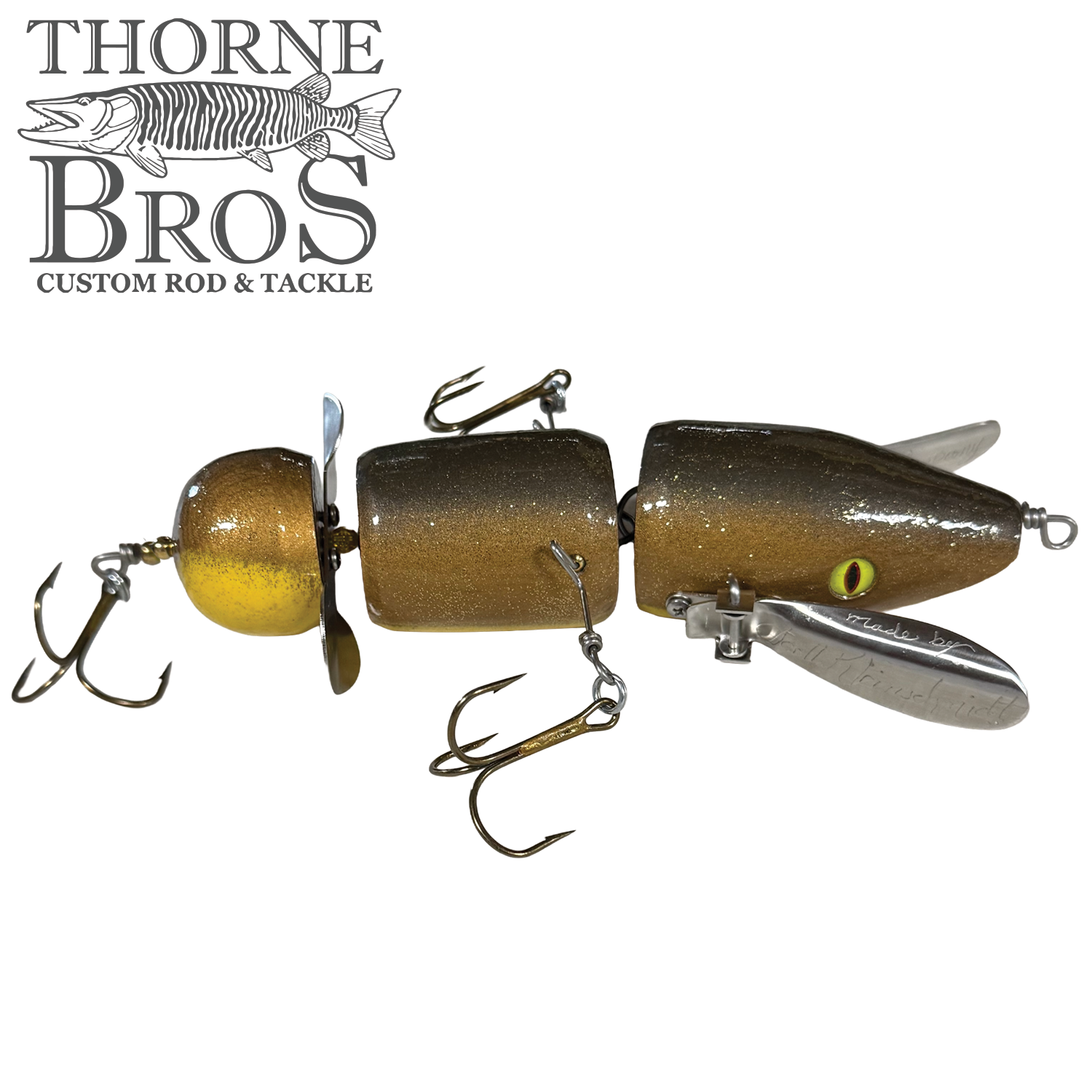 Musky Safari Franken Spitz fishing lure with segmented brown and gold body, multiple treble hooks, metal propeller, and silver fins designed for musky fishing.