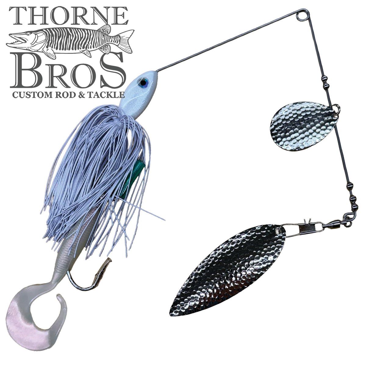 Ace Baits Monster Spinnerbait featuring a blue and silver skirt with twin textured blades and a soft paddle tail for musky fishing tackle