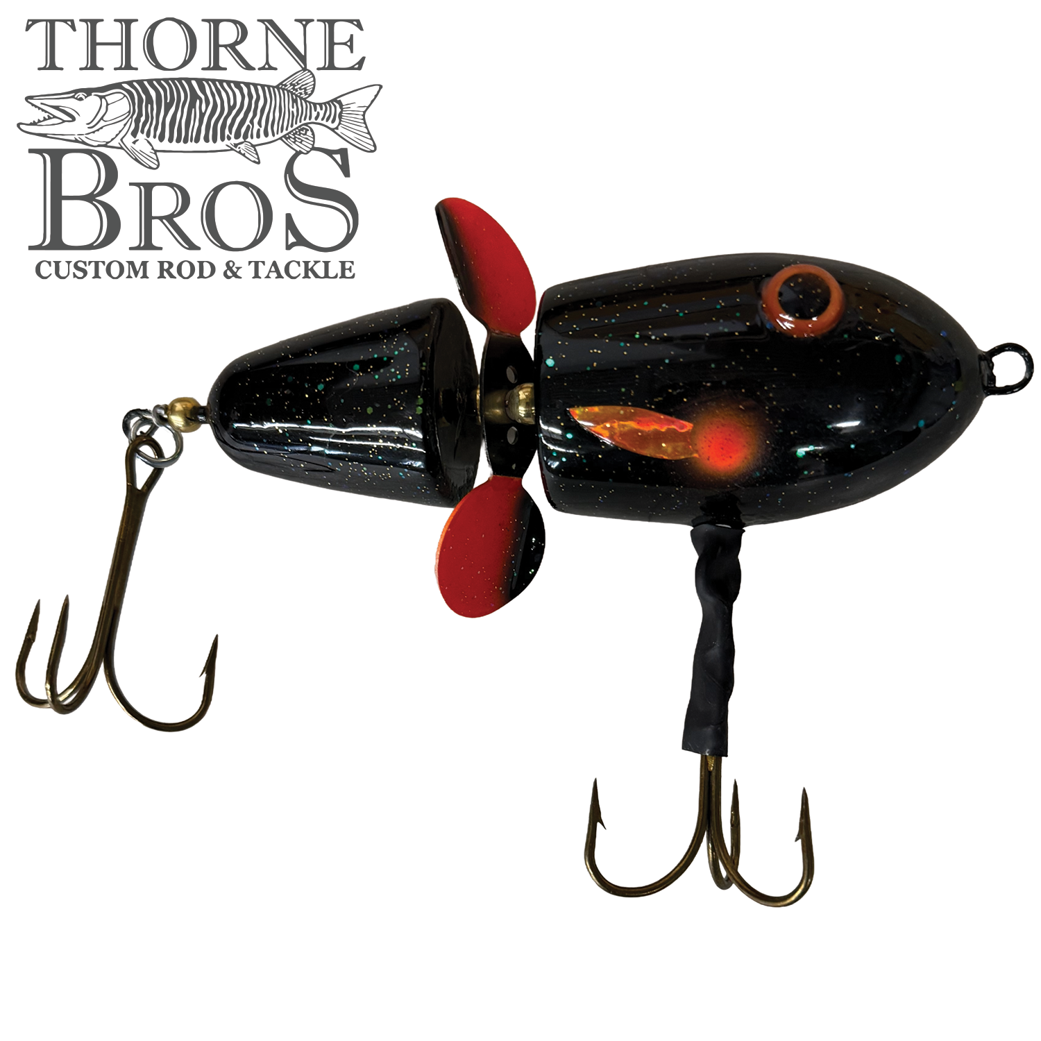 Lake-X Hammer fishing lure with a segmented black body featuring orange accents, two treble hooks, and a red propeller designed to attract musky fish.