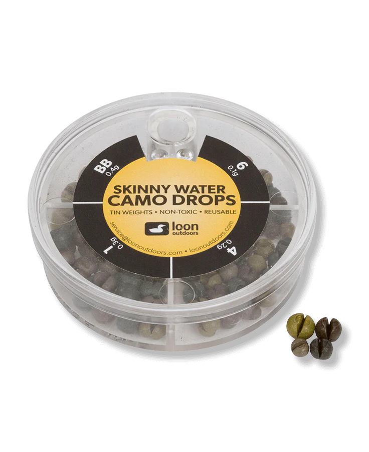 Clear round plastic container holding various sizes of camo-colored tin fishing weights with "Loon Tin Drop Assortments" label on top, alongside four sample weighted drops.