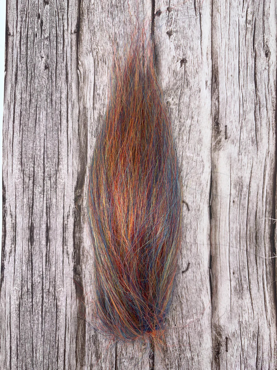 A close-up image of a multicolored fishing lure material bundle named Squimpish Sparkle Blend, featuring fine strands in shades of orange, blue, and green, used for fly fishing and fishing tackle.