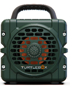 Turtlebox Cub portable speaker in dark green with a sturdy black handle and orange center grille shown against a white background