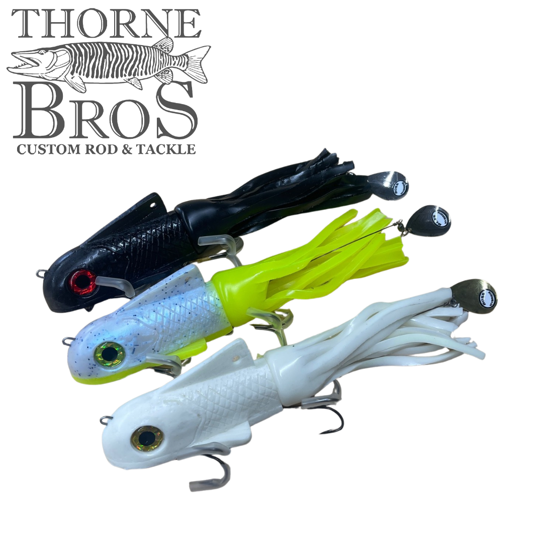 Three Boss Shad Medium Hybrid - Shallow fishing lures in black, lime green, and white with detailed eyes and soft skirted tails, displayed against a plain background with Thorne Bros logo.