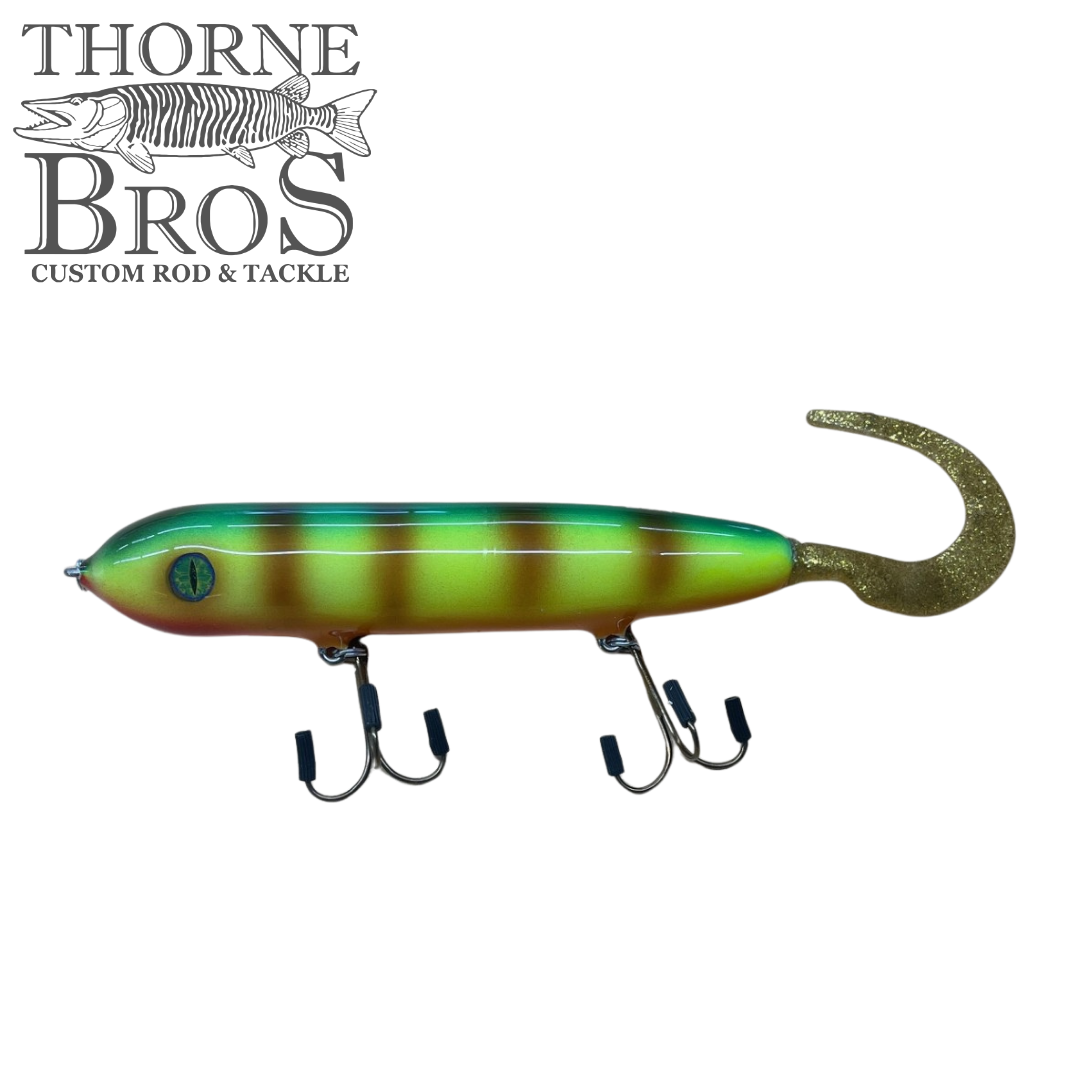Holmgren Serpent Musky Top Water lure in green and yellow stripes with a curved tail and two double treble hooks, designed for musky fishing tackle.