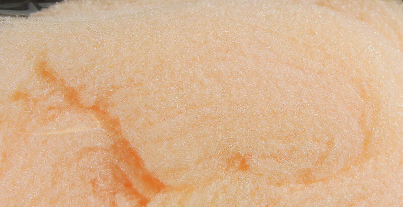 Close-up of pale orange Hareline McFly Foam with textured, slightly porous surface used for crafting fishing lures and fishing tackle.