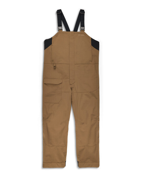 Simms Men's Challenger Rain Bib in brown with black adjustable shoulder straps, multiple pockets, and reinforced knee patches, designed for fishing and outdoor water resistance.