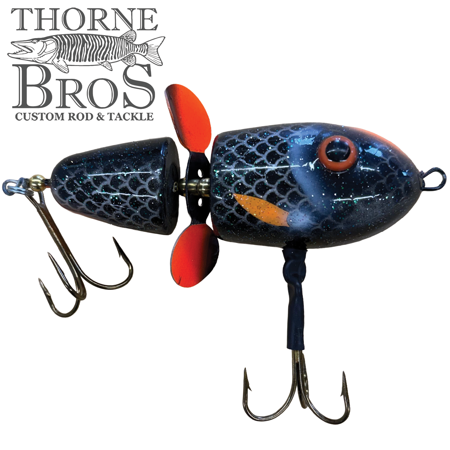 Lake-X Hammer fishing lure with segmented black body, orange markings, two treble hooks, and red propeller detail, designed for musky fishing.