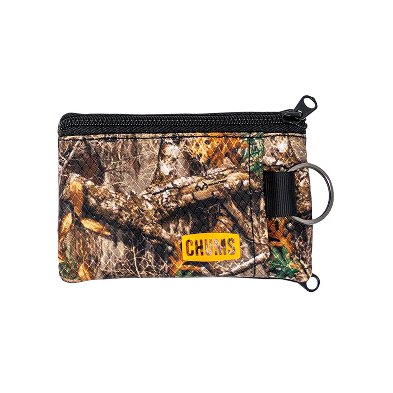 Chums Surfshorts Wallet in camo pattern with black zipper, yellow logo patch, and attached metal keyring, designed for secure storage of small items during fishing trips.