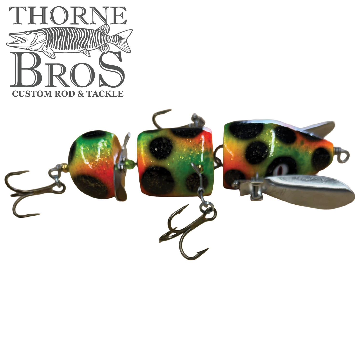 Thorne Bros Musky Safari Franken Spitz Jr. jointed musky fishing lure with colorful frog pattern and treble hooks displayed on a white background.
