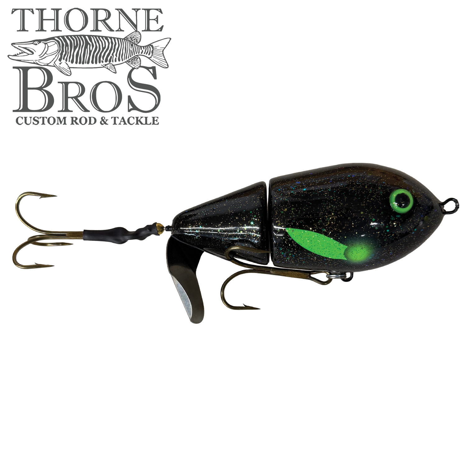 Close-up view of the Lake-X Cannonball JR. fishing lure in black with green accents, featuring dual treble hooks and a segmented body designed for realistic movement in water.