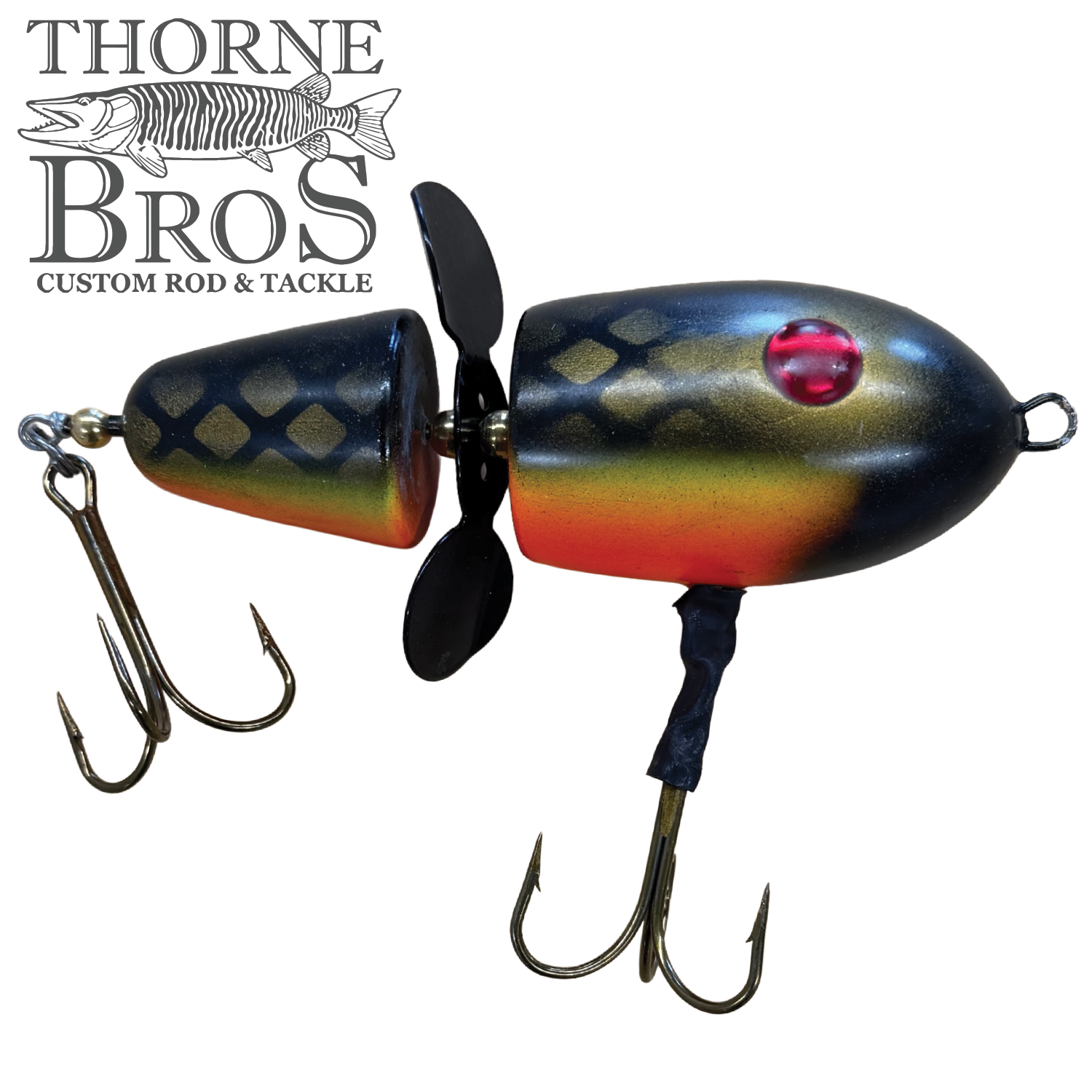 Close-up of the Lake-X Hammer fishing lure featuring a segmented black and yellow body with red eyes, two treble hooks, and a small propeller for musky fishing.