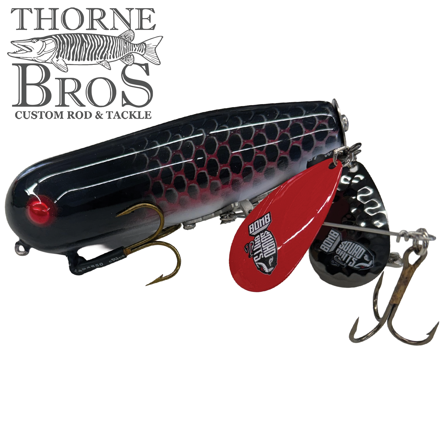 Bomb Squad Double Tap Flap Tail fishing lure with a black and red scale pattern, bright red spinner blades, and sharp treble hooks designed for musky fishing.