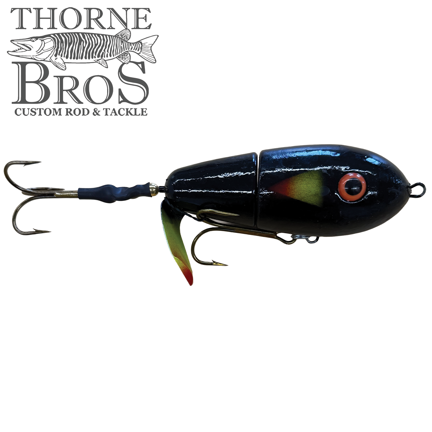 Black segmented fishing lure with orange eye and red-tipped fins, featuring two treble hooks, designed as the Lake-X Fat Bastard for musky fishing.