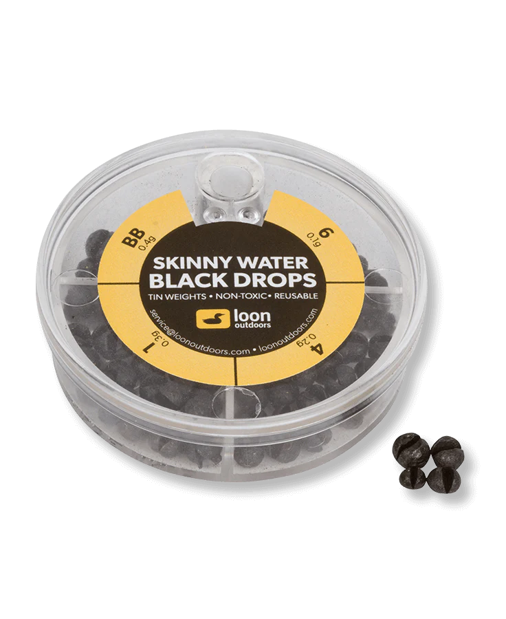 Loon Tin Drop Assortments featuring a clear round container filled with small black tin fishing weights in various sizes, designed for precise fishing tackle adjustments.