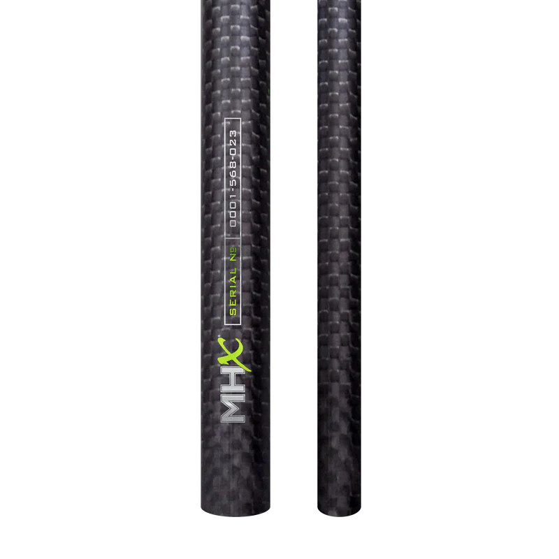 Close-up of two black carbon fiber fishing rod blanks with textured weave pattern, featuring "MHX" label and serial number, part of Bushido 3K Rod Blanks (2 piece) set.