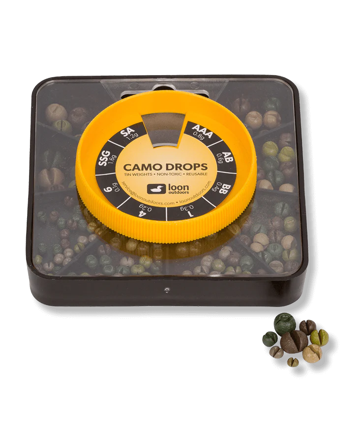 Compact black and yellow plastic container holding assorted camo-colored tin fishing weights with various sizes visible, labeled "Loon Tin Drop Assortments" for fishing tackle use.