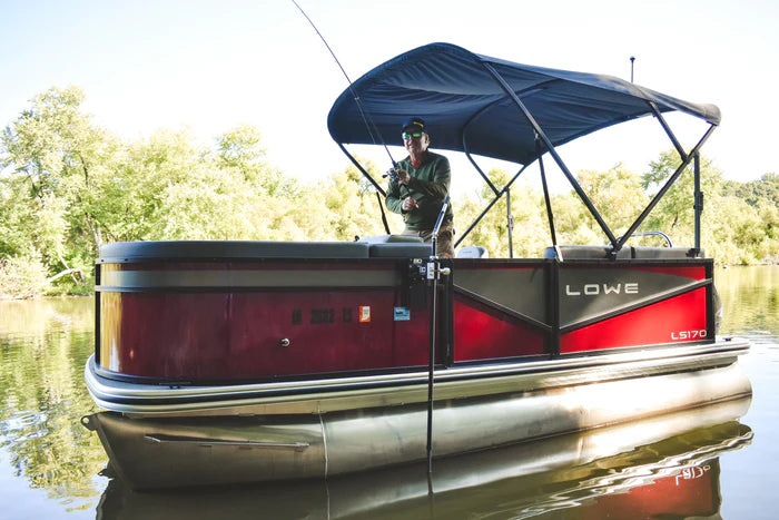Man fishing from a red and black Lowe LS170 pontoon boat equipped with a Beatdown Outdoors Pontoon - Fixed Transducer Pole SKU:TPOLE-FIXED-AT-PONTOON on calm water surrounded by green trees.