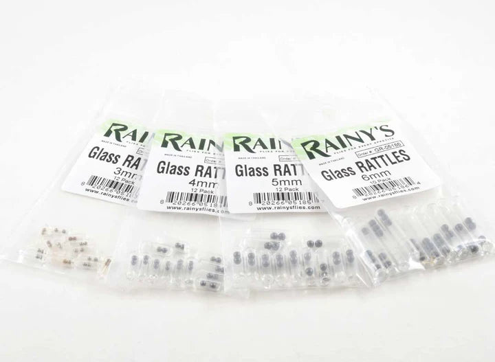 Clear plastic packages of Rainy's Glass Rattles in various sizes, small cylindrical fishing tackle components used to create noise in fishing lures for enhanced attraction.