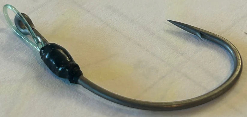 Close-up of Limitless Felix's HALO Ryugi fishing hook featuring a sharp curved point and durable black and metallic finish, designed for musky and ice fishing tackle.