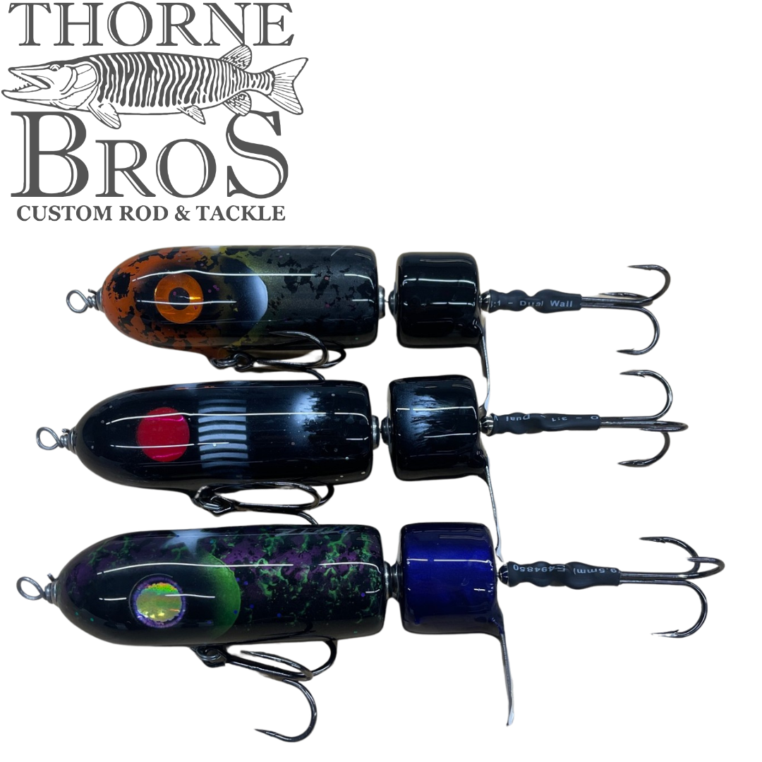 Zilla Baits PropWash musky fishing lures in orange black blue and green finishes with propeller tails and treble hooks displayed on a white background