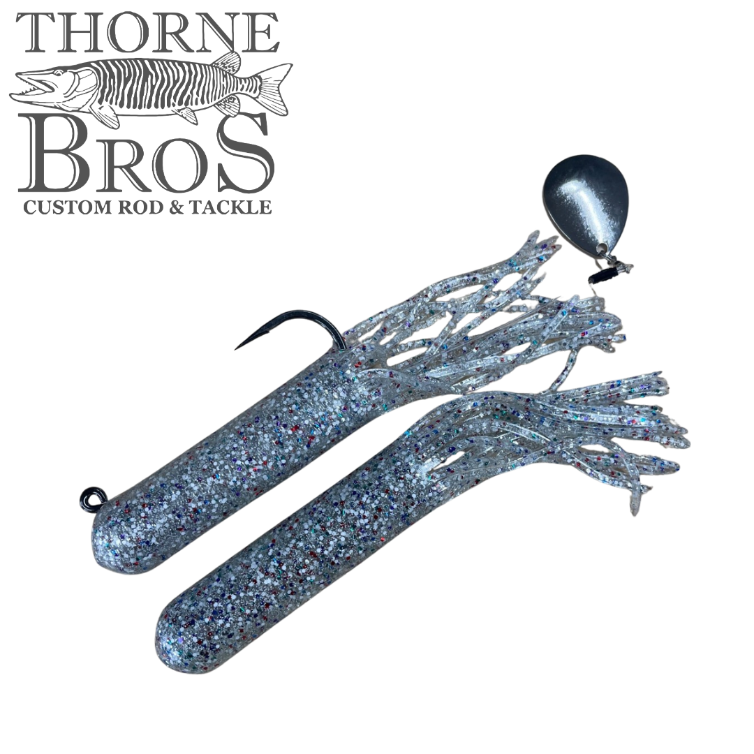 Drop Tine Chunker Tubes fishing lures in glittery blue, featuring flexible skirted bodies with hooks and a silver blade attachment, designed for musky fishing tackle.