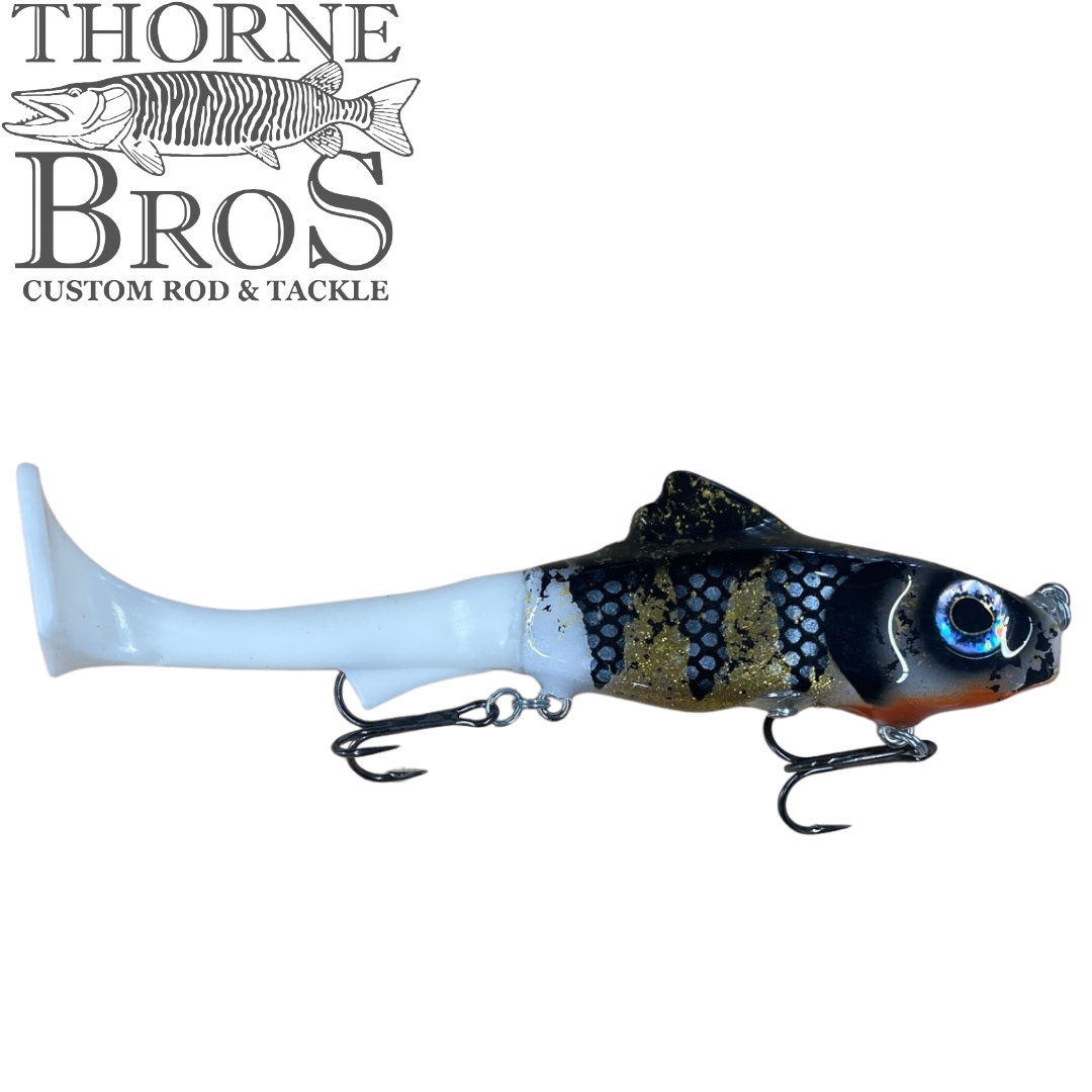 Zilla Baits Hooker fishing lure featuring a black, gold, and white segmented body with realistic eyes and dual treble hooks, designed for musky fishing tackle.