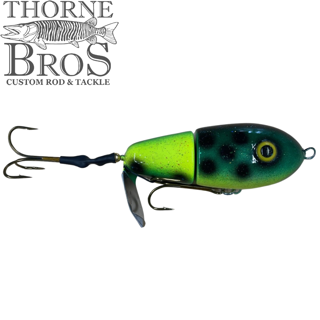 Green and black jointed fishing lure with treble hooks and metal spinner blade, designed for musky fishing, labeled Lake-X Fat Bastard (Epoxy Finish)