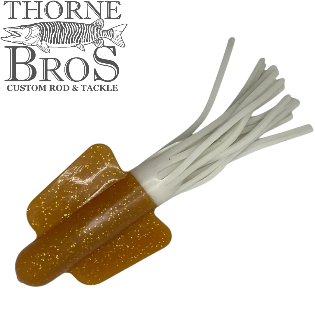 Angling Revolution Squiddy Tube brown glitter fishing lure with white tentacles for musky fishing tackle beside the Thorne Bros custom rod and tackle logo