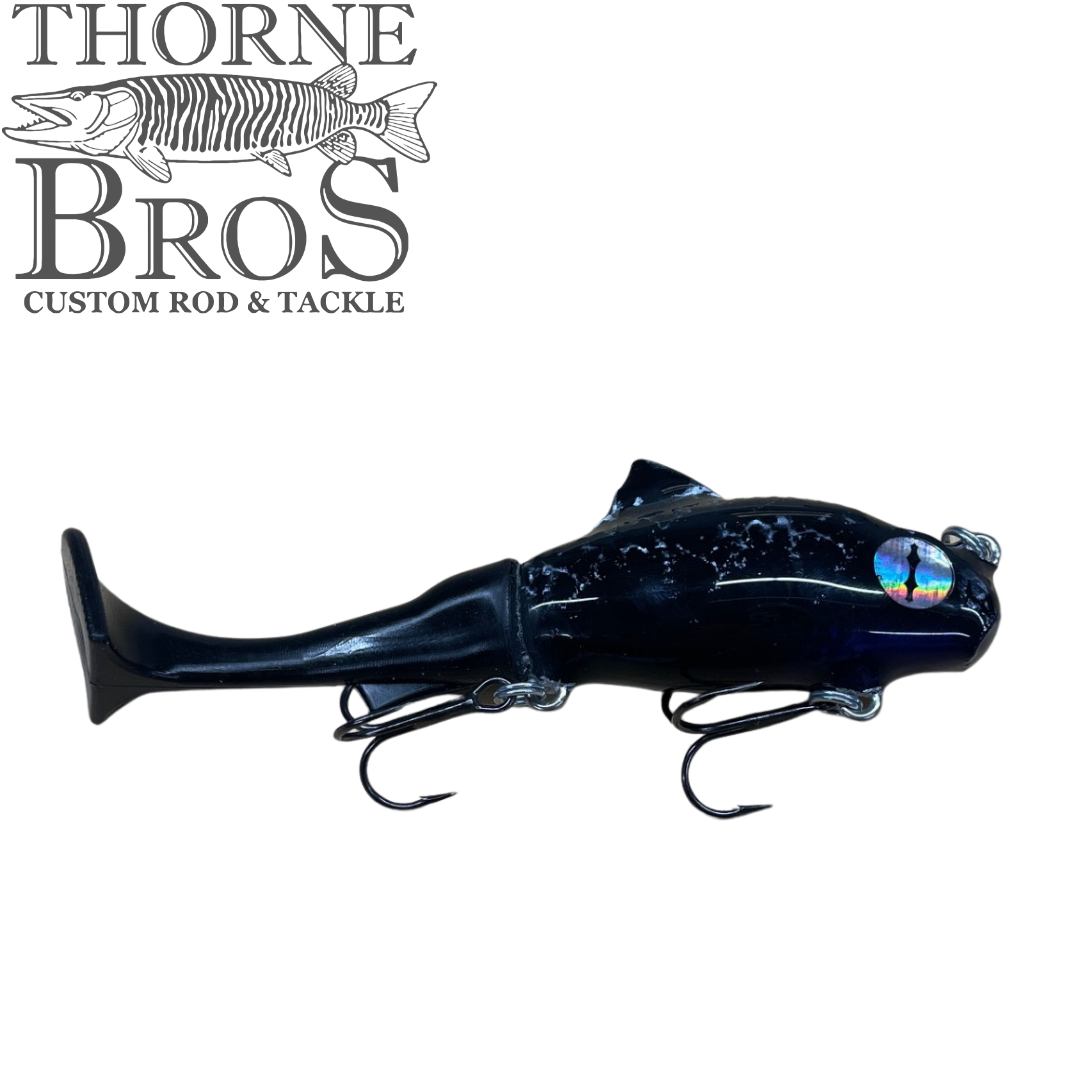 Zilla Baits TicTak black musky fishing lure with two treble hooks and reflective eye beneath the Thorne Bros Custom Rod and Tackle logo