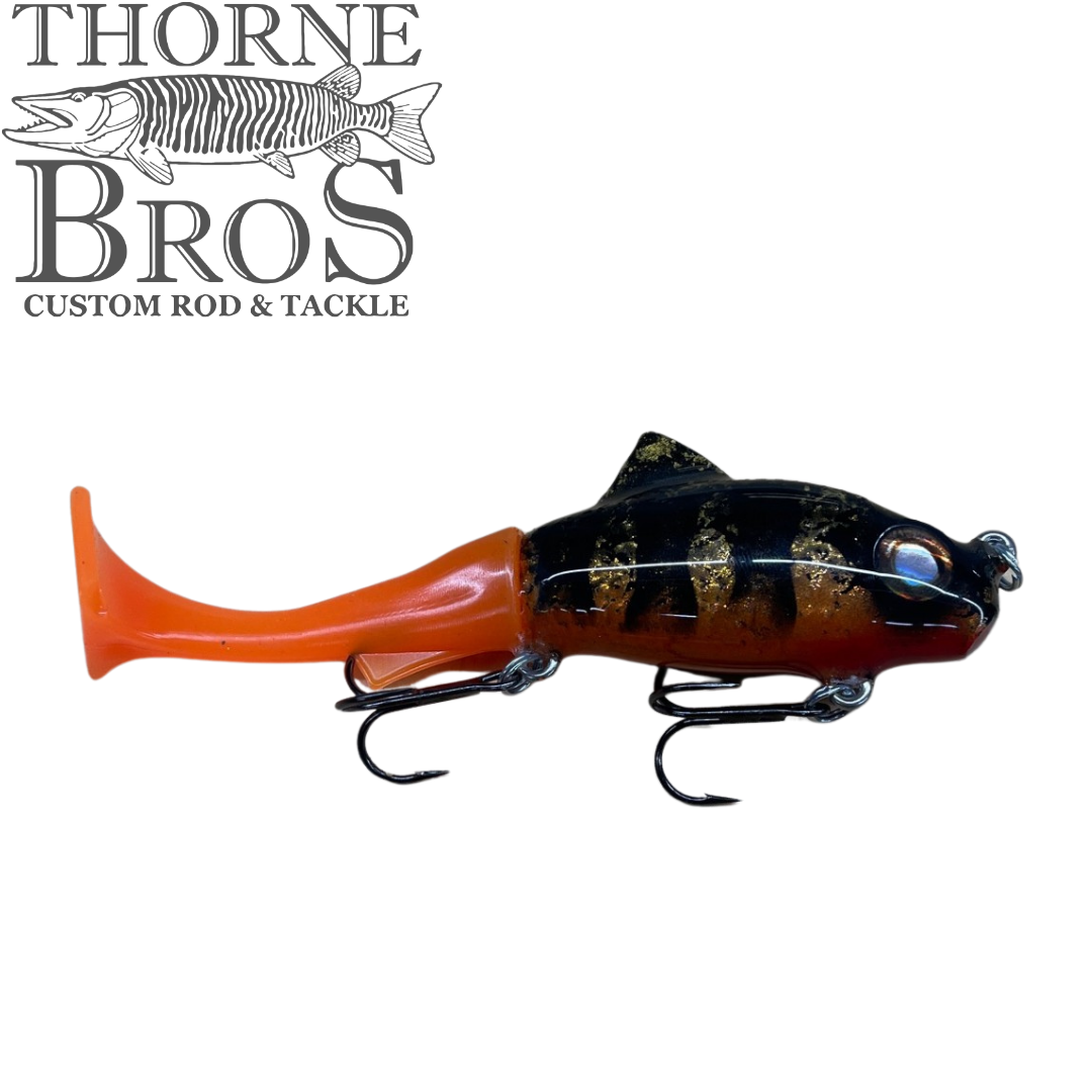 Zilla Baits TicTak musky fishing lure in black and orange with realistic fish details and treble hooks beside the Thorne Bros Custom Rod and Tackle logo