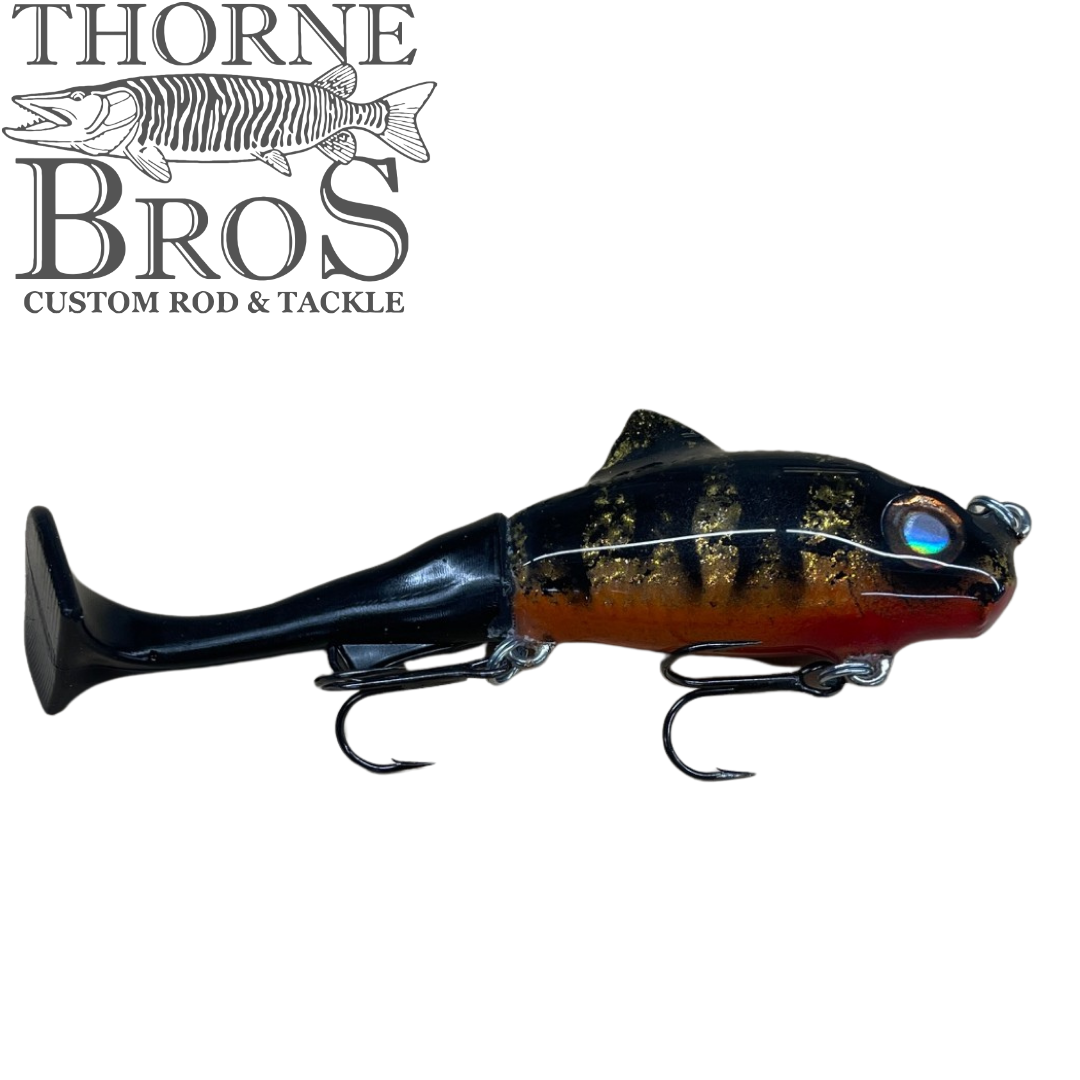 Zilla Baits TicTak musky fishing lure in black gold and red with a blue eye and twin treble hooks shown under the Thorne Bros logo