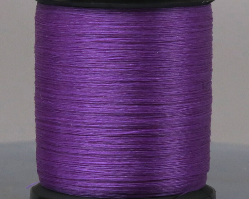 Close-up of a spool of vibrant purple UNI 8/0 Thread used for tying fishing lures and flies, suitable for musky tackle and custom fishing rods.