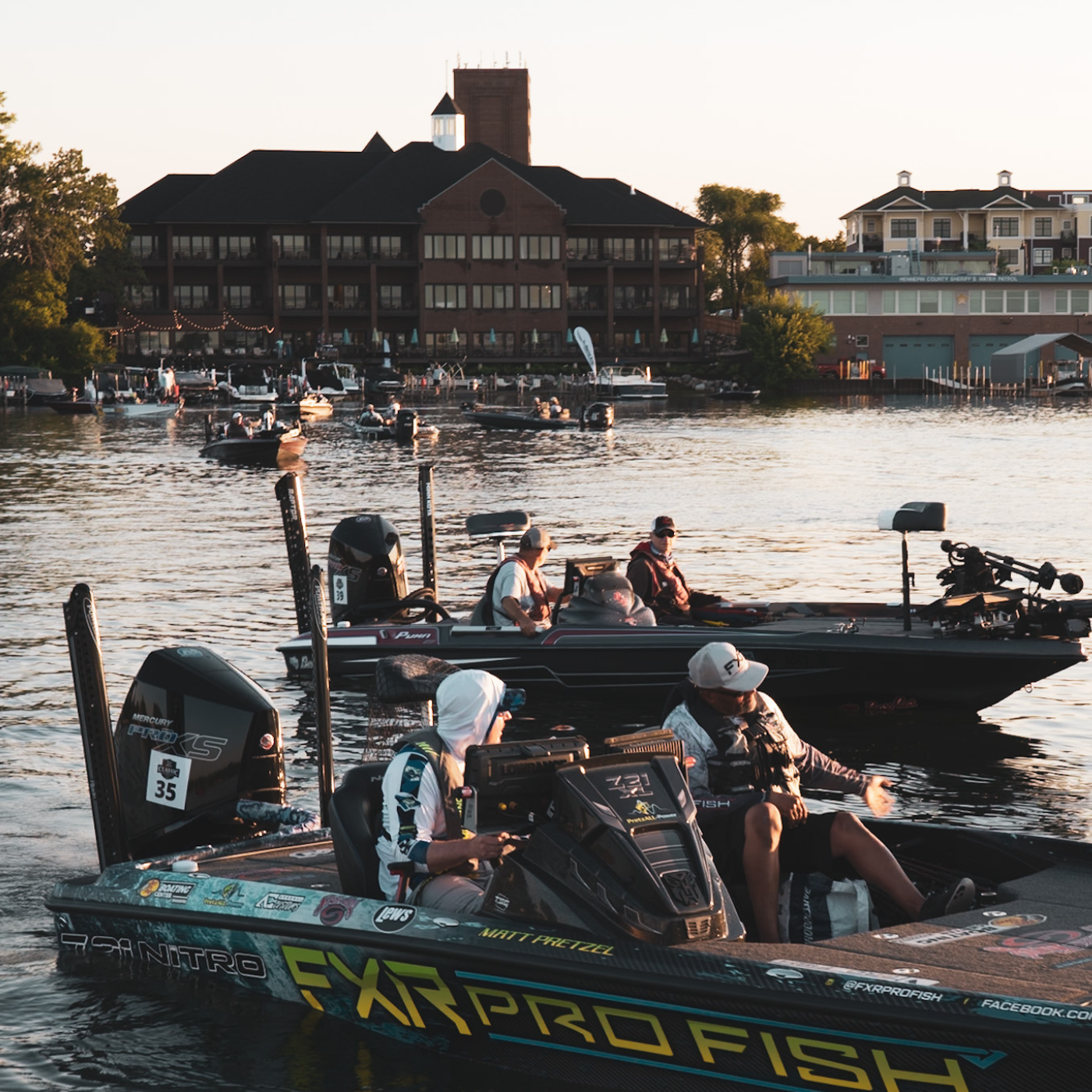 Boats on lake parked in front of shoreline hotel