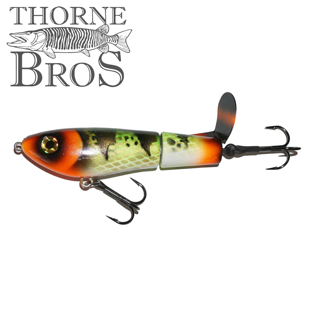 Bucher Topraider fishing lure designed with segmented body in orange, green, and black tones, featuring two treble hooks and a rear propeller for musky fishing.