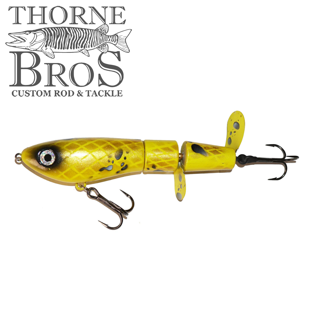Bucher Super Topraider yellow jointed fishing lure with black spots, detailed eye, two treble hooks, and propeller fins designed for musky fishing.