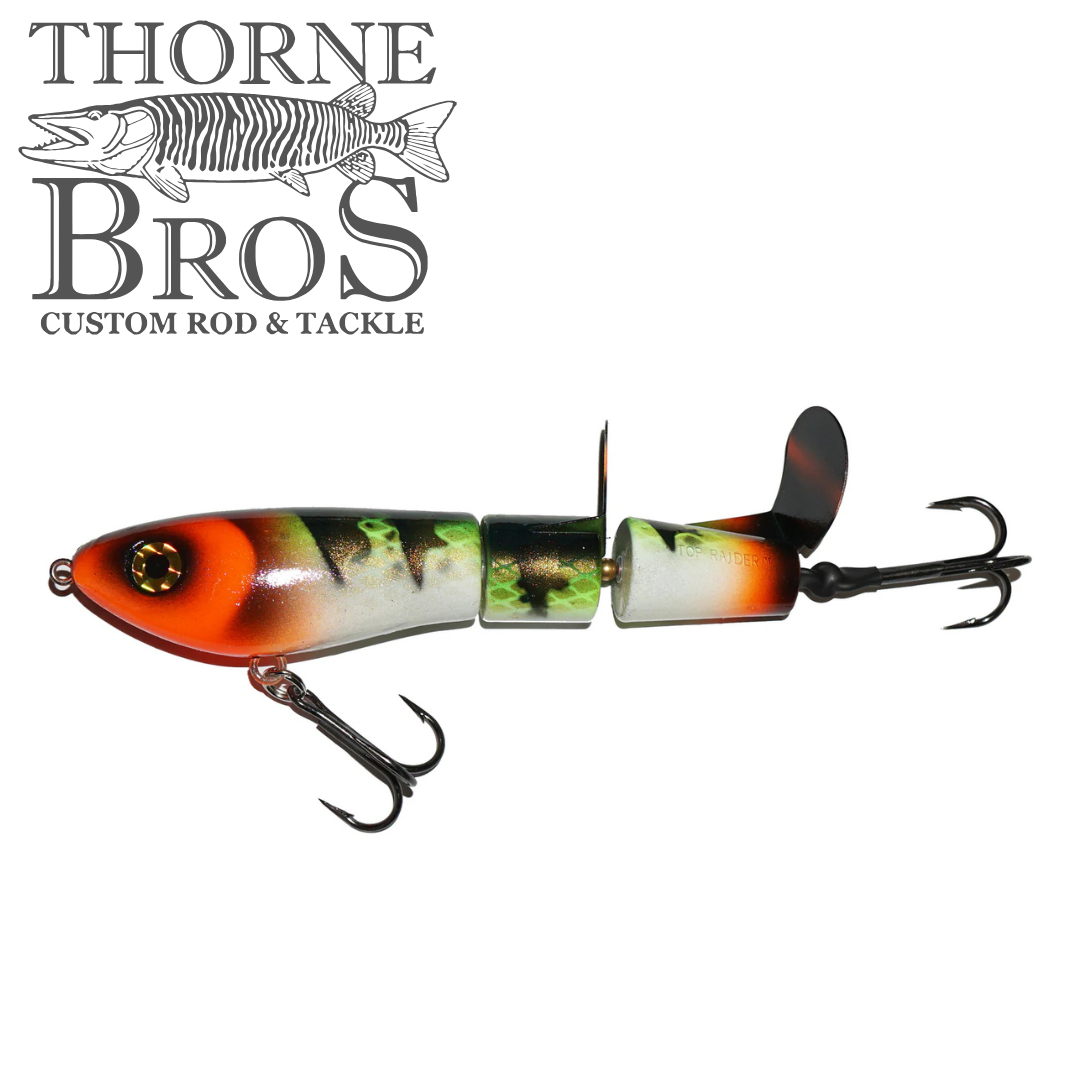 Bucher Super Topraider fishing lure with segmented body and vibrant orange, green, and black pattern designed for musky fishing, featuring sharp treble hooks and a propeller tail.