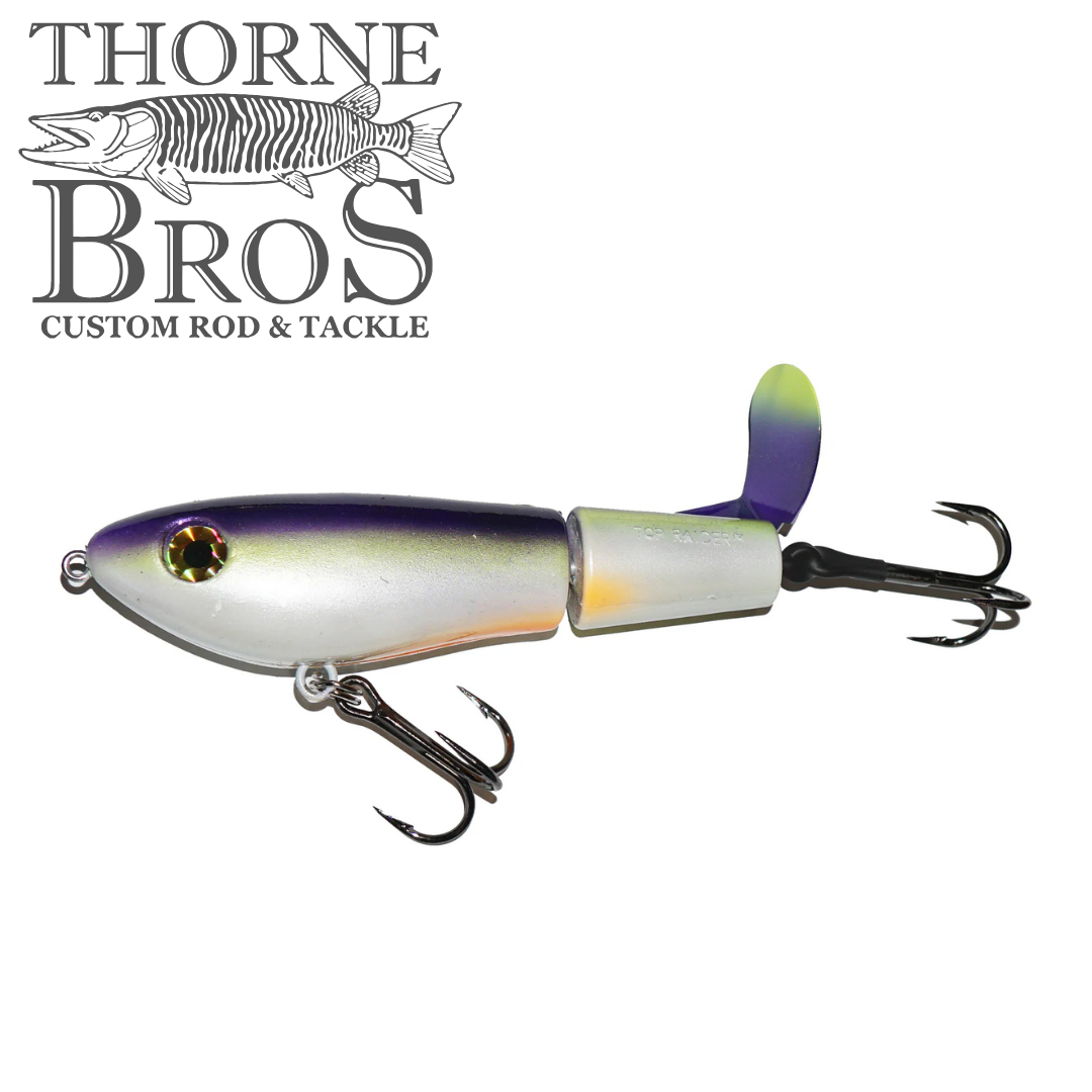 Bucher Topraider fishing lure with silver and purple body, detailed design, two treble hooks, and a rear propeller for musky fishing tackle by Thorne Bros.
