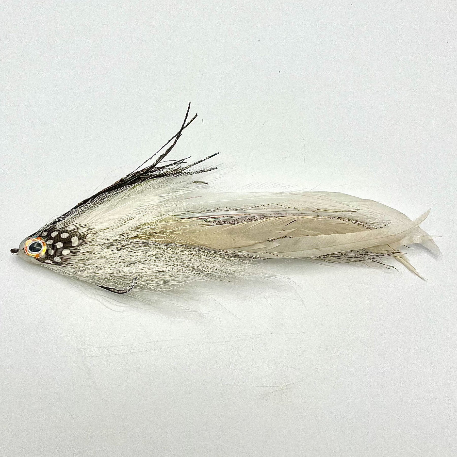Single Minnow Urban Fly Co. fishing lure with white and black feathers, detailed eyes, and a hook designed for musky and fly fishing tackle.