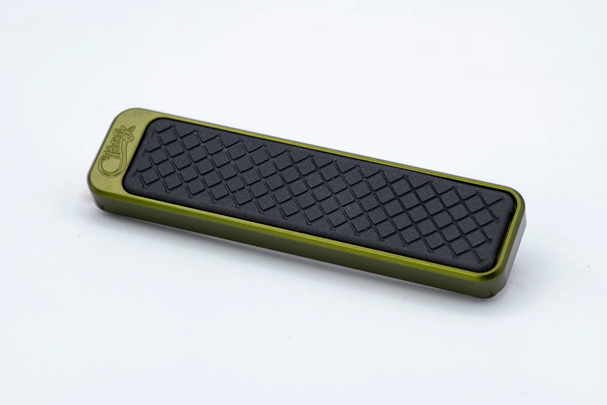 Cling Tool Stick Mini featuring a compact, rectangular design with an olive green body and textured black gripping surface, ideal for organizing fishing tackle.