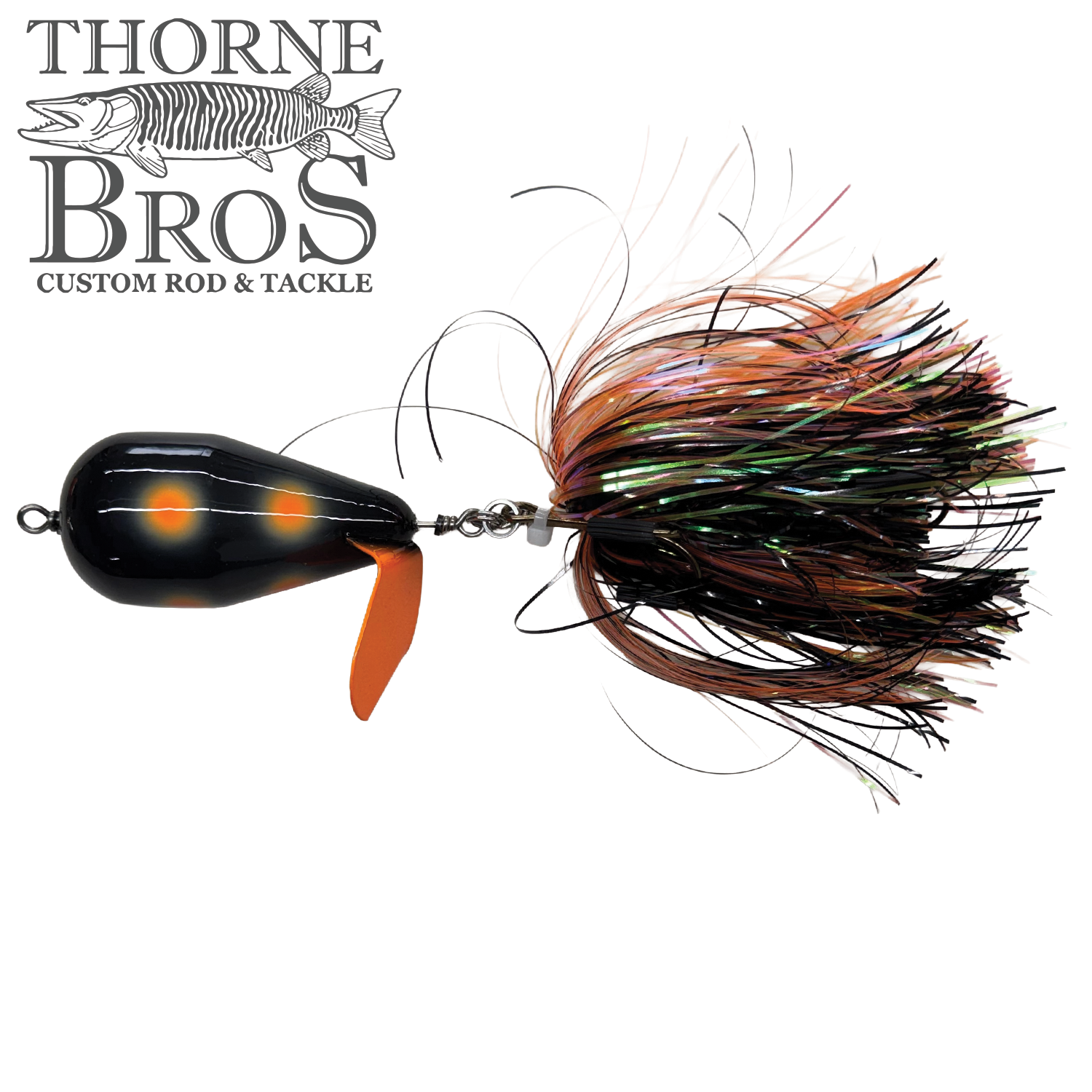 Spanky Baits Violence fishing lure with a black body featuring orange spots, an orange propeller blade, and a skirt of multicolored strands for musky fishing.