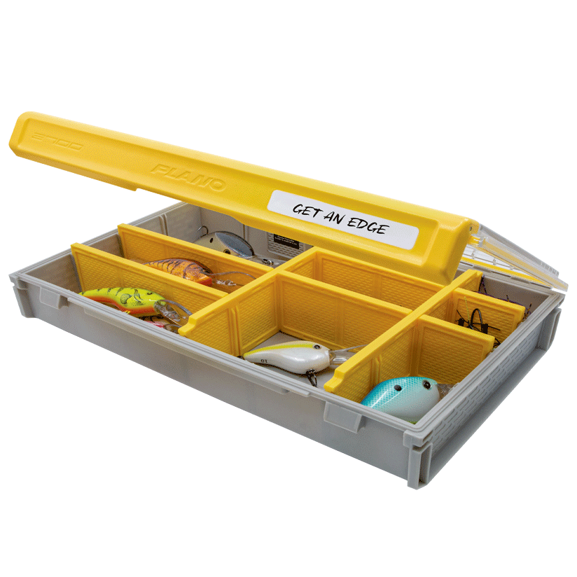 Plano EDGE 3700 Flex fishing tackle box with yellow lid and multiple compartments containing various fishing lures, designed for organized storage of fishing gear.